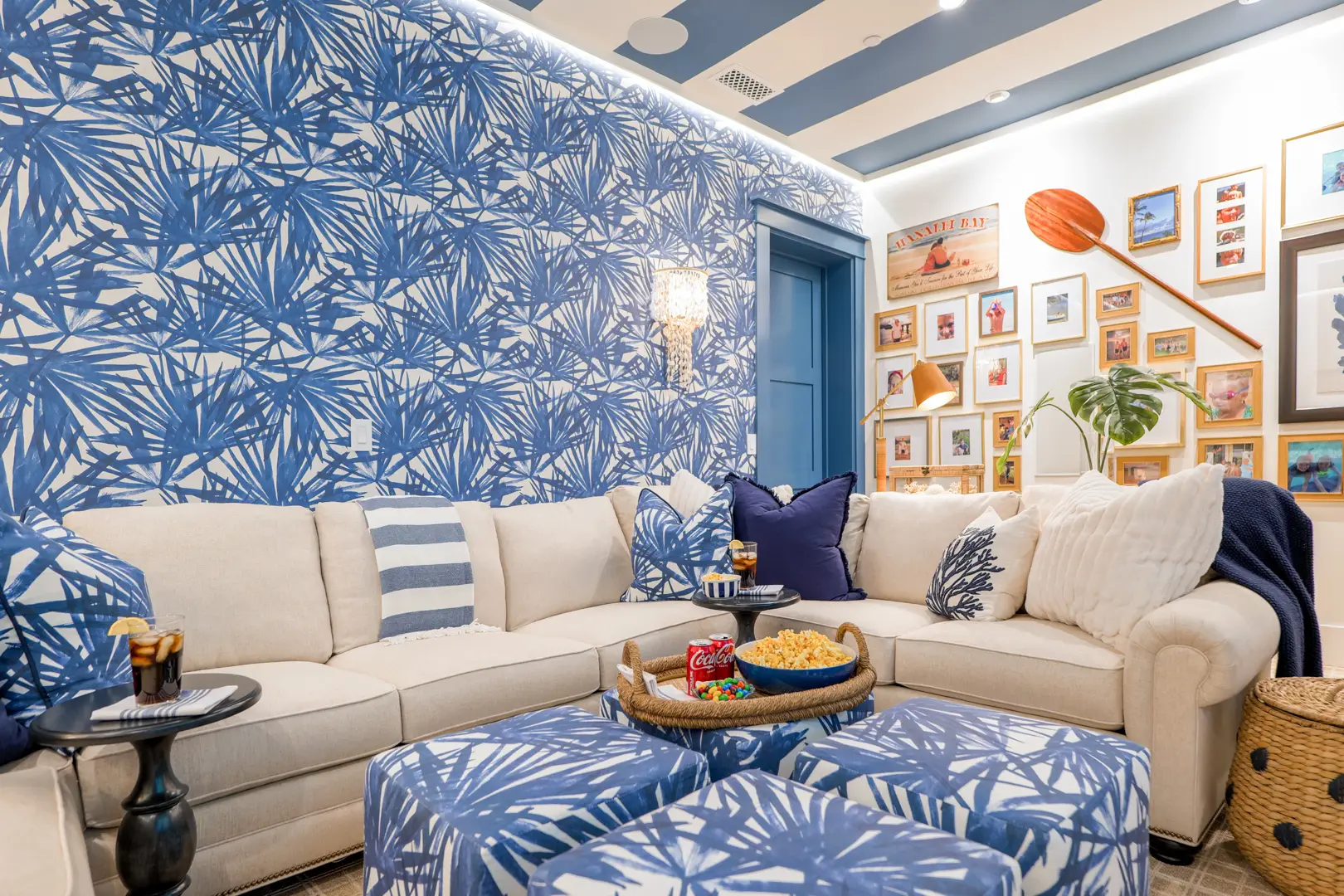 Luxury interior design media room with blue palm frond pattern and gallery wall
