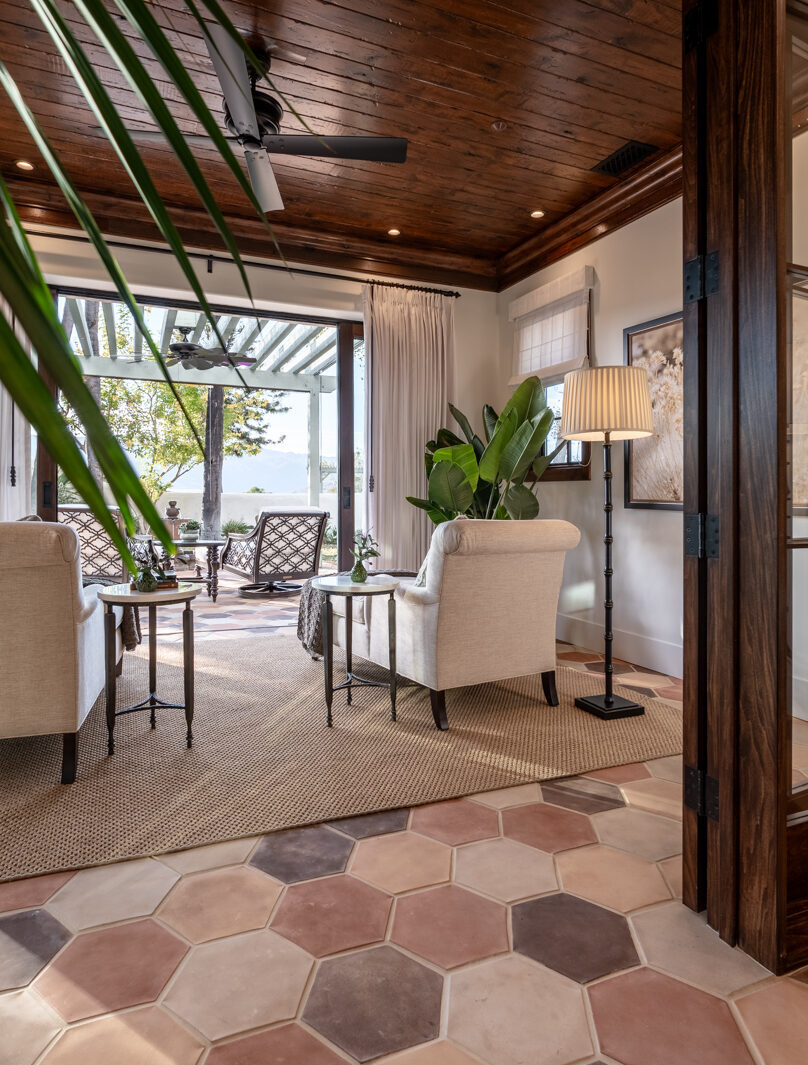 Luxury interior design sunroom with clay tile, dark wood details, and French doors to outdoor space