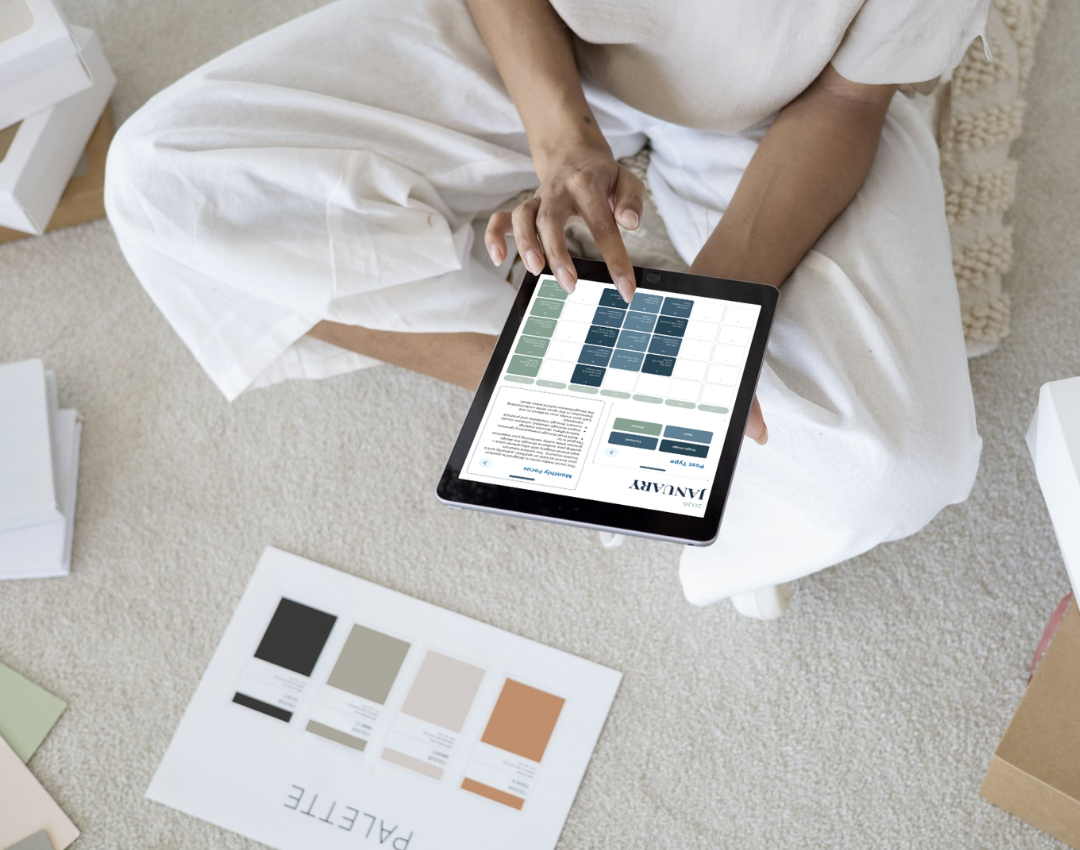 Content creator reviewing social media calendar on iPad while sitting on floor